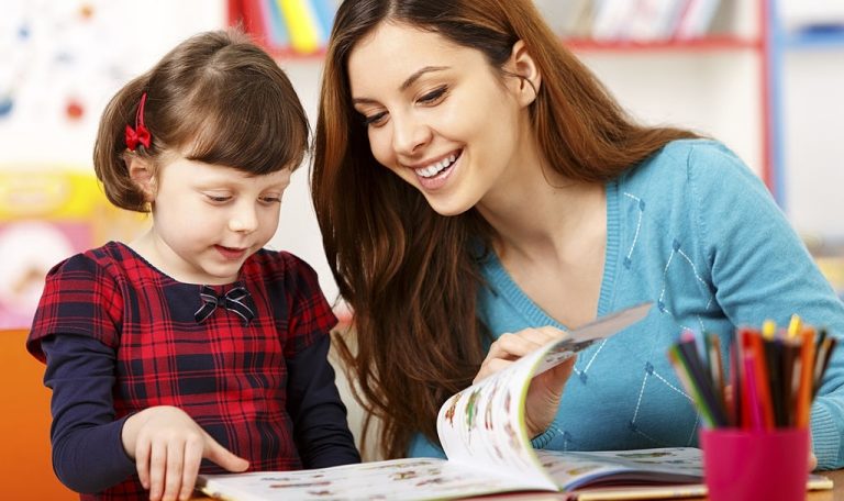 Child reading with a preschool teacher